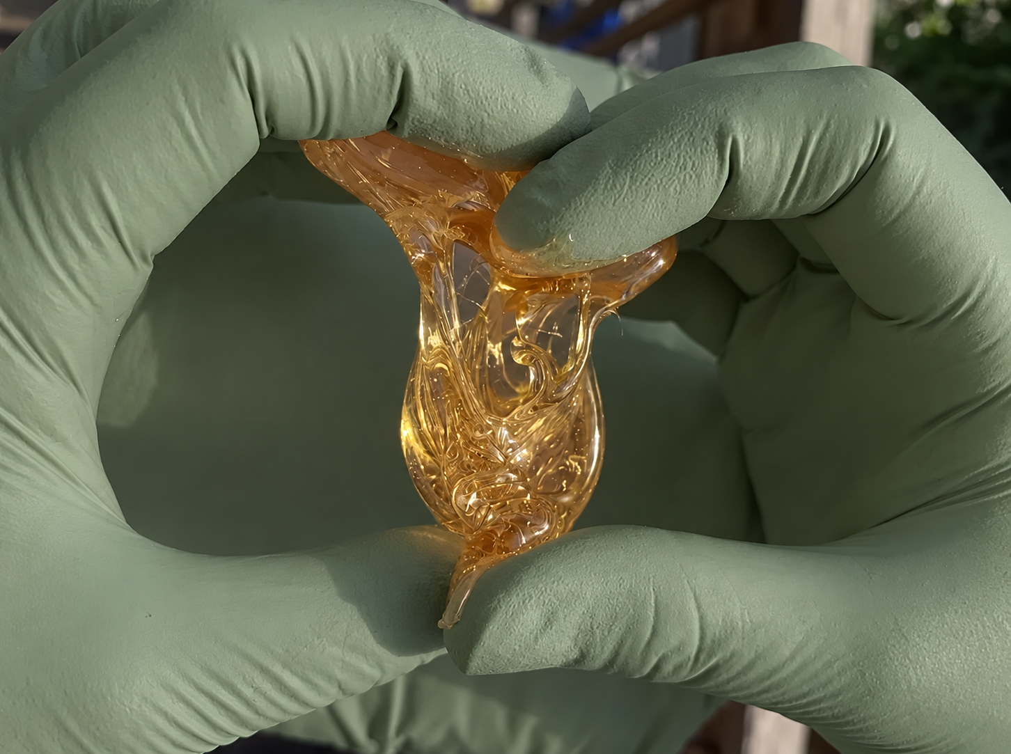 Professional sugaring technique demonstrated with green gloves and golden sugar paste